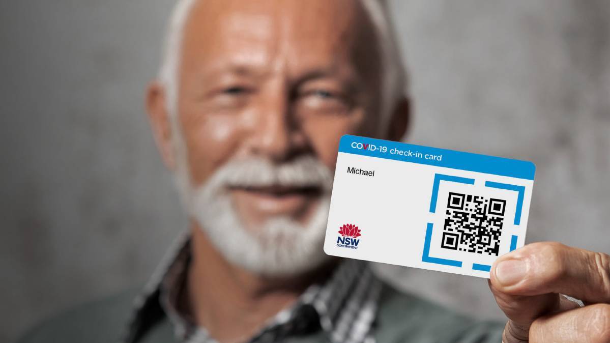 photo of man holding a covid check-in card